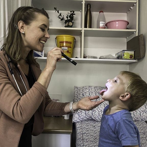 Dr. Rockhill checking a child's throat
